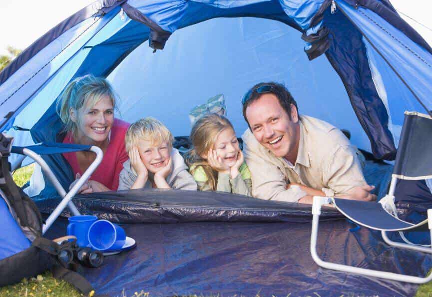 Familia de 4 miembros acampando en el jardín para compartir una experiencia juntos