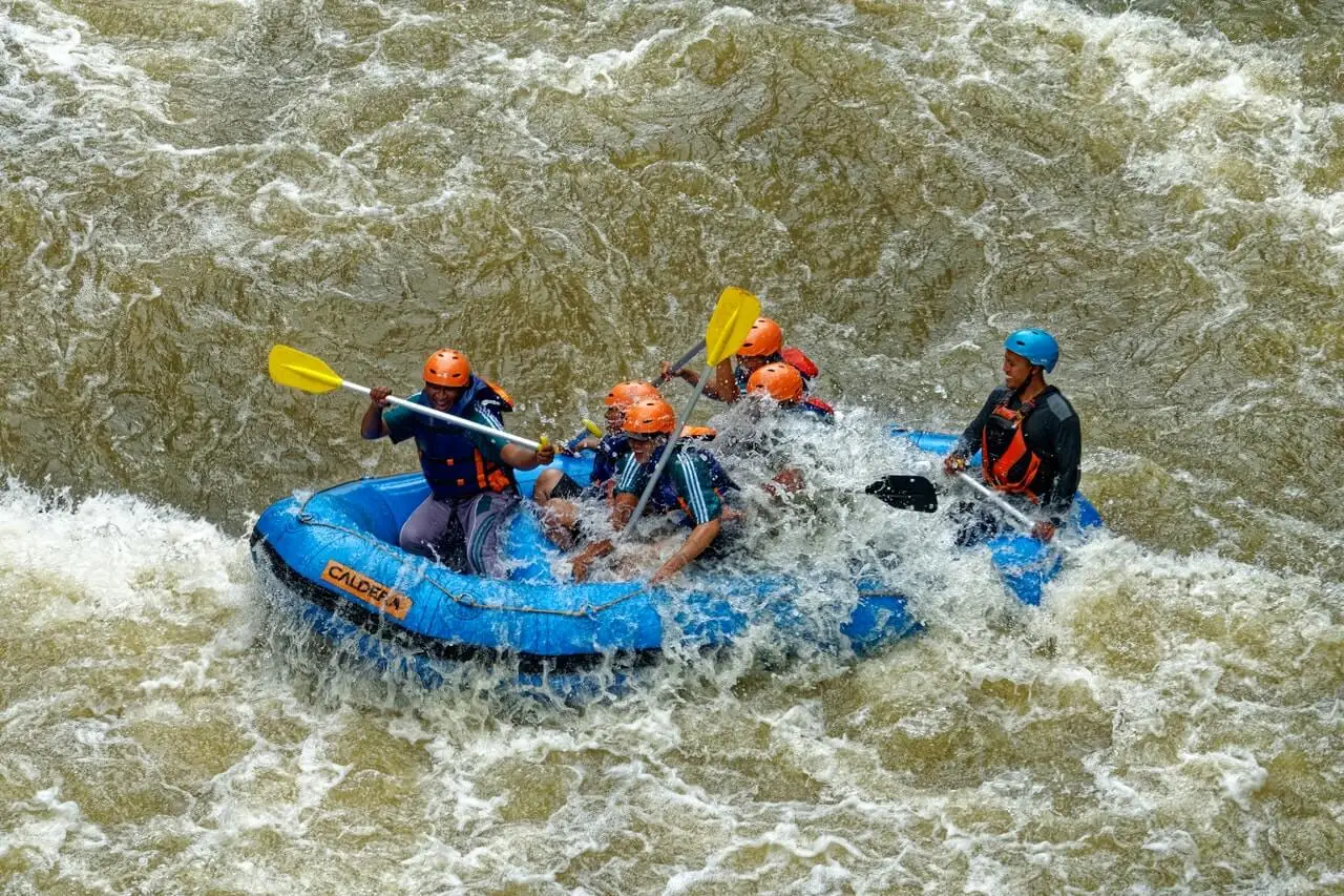 abenteuerlustige Menschen - Gruppe beim Wildwasserrafting