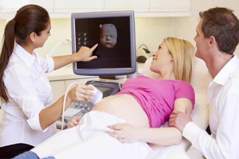 Médica realizando una ecografía a una embarazada.