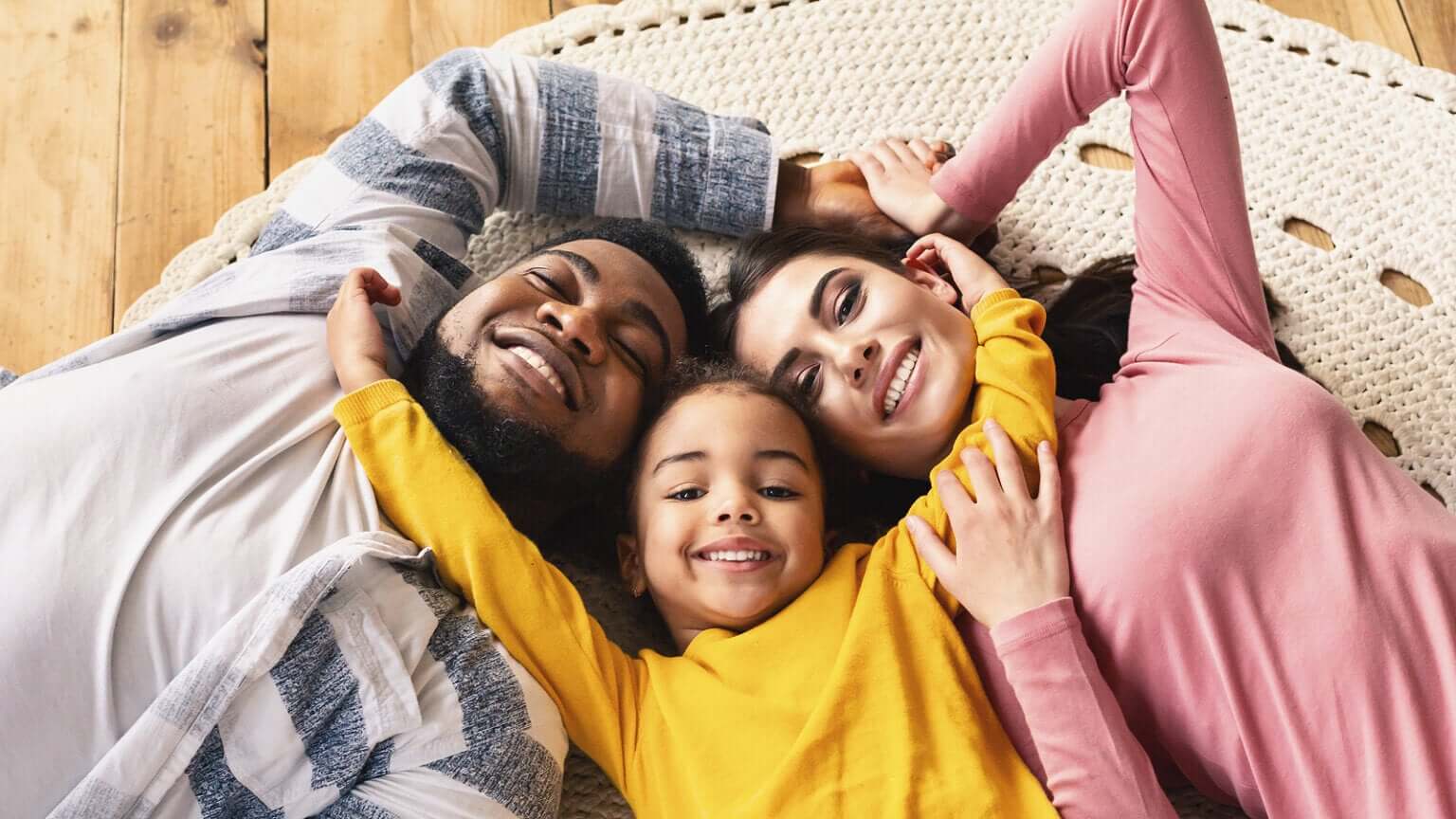Familia unida tumbada en el suelo.