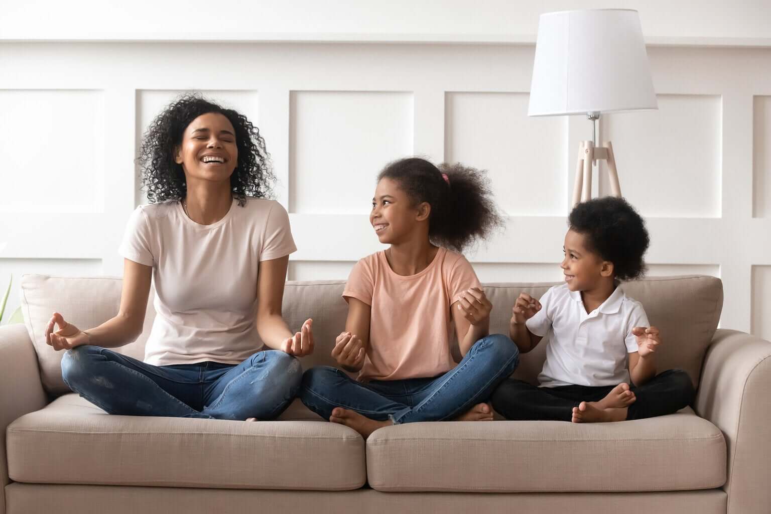 Madre con sus hijos riendo y meditando.
