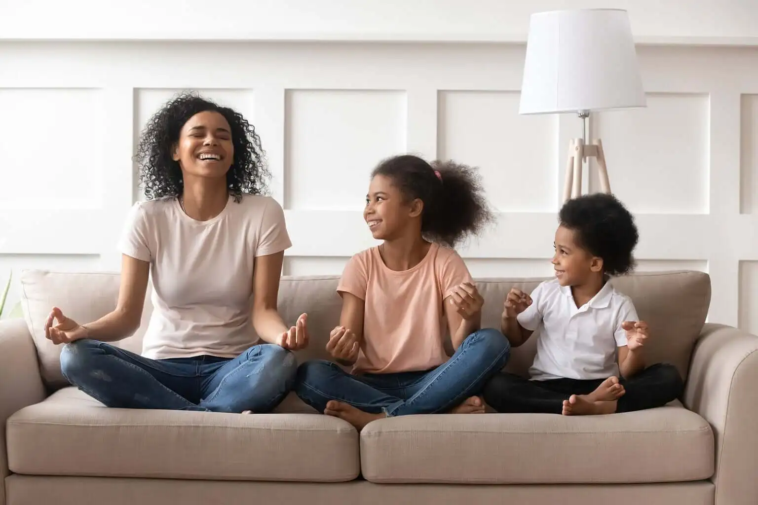 Madre con sus hijos riendo y meditando.