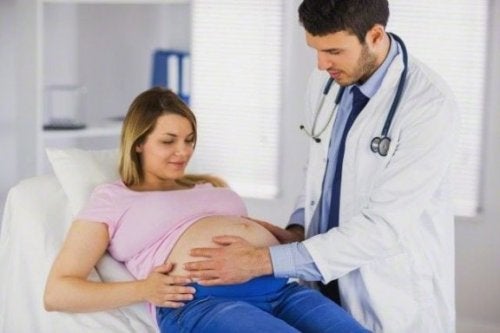 Mujer embarazada siendo atendida por el doctor en la clínica