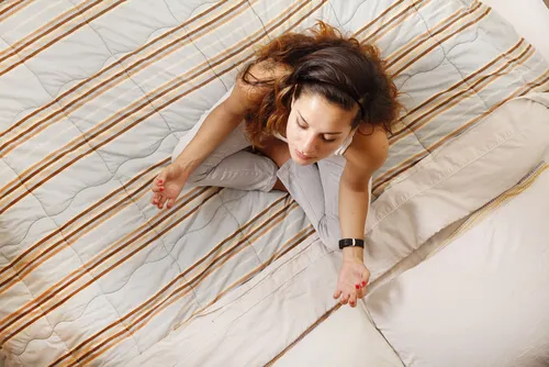 Mujer meditando en la cama