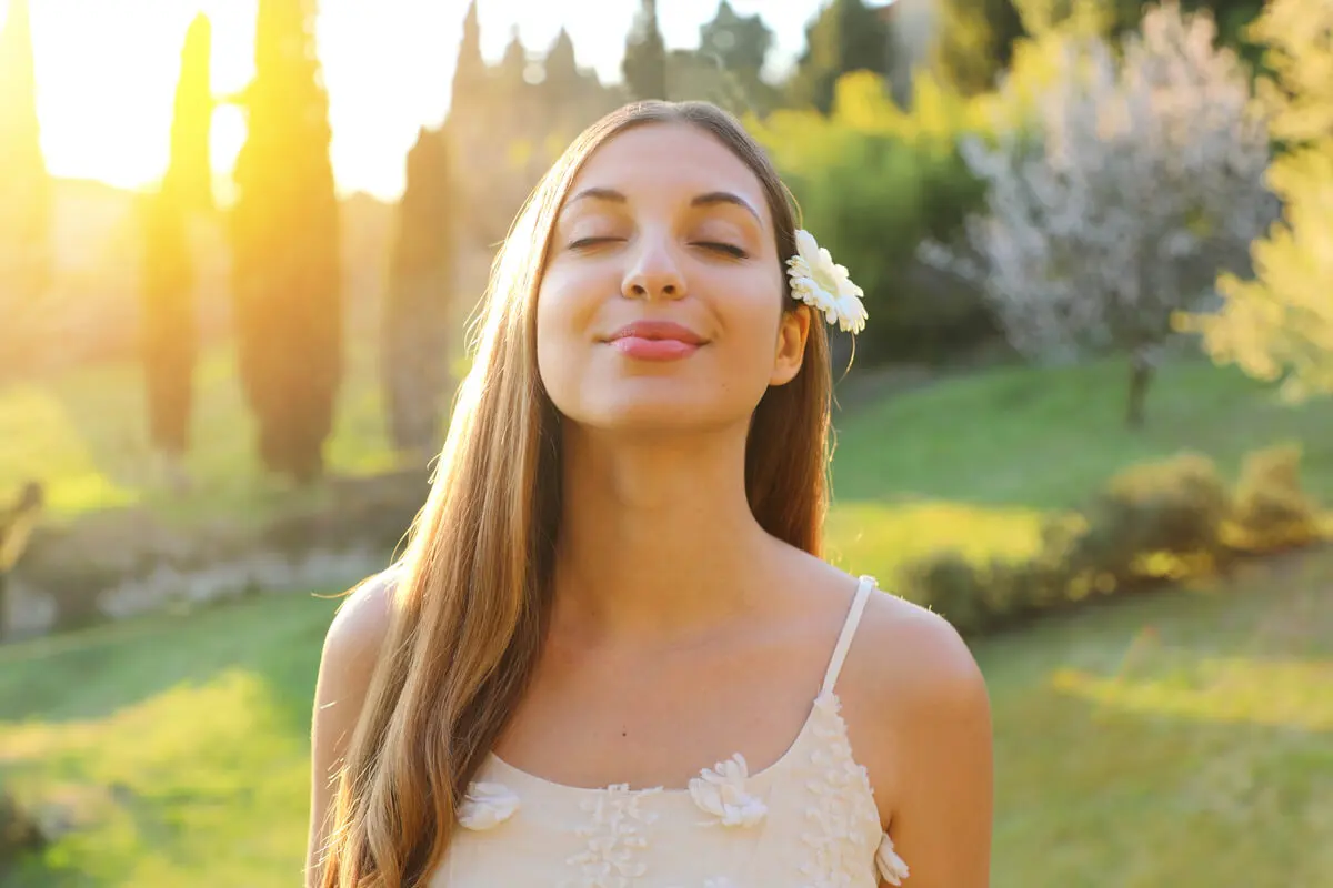 Mujer con los ojos cerrados y una flor en el pelo