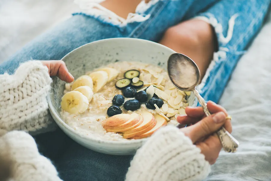 Mujer con plato de bircher muesli en invierno.