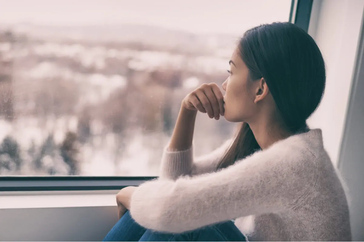 Mujer sola mirando por la ventana