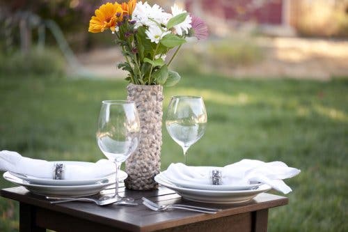 Florero con tubo de cartón sobre una mesa elegante