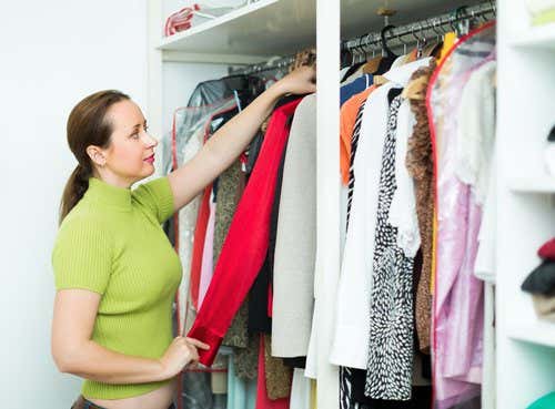 Mujer colocando ropa en el armario