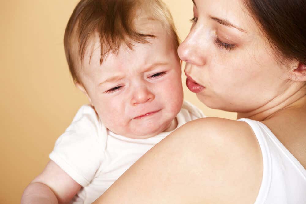 Die Bindungstheorie - Mutter mit weinendem Baby auf dem Arm