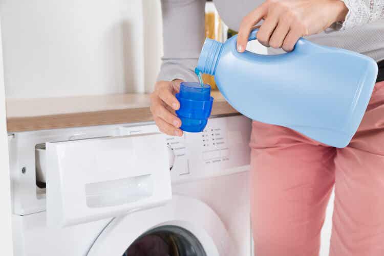 Mujer echando detergente a la lavadora