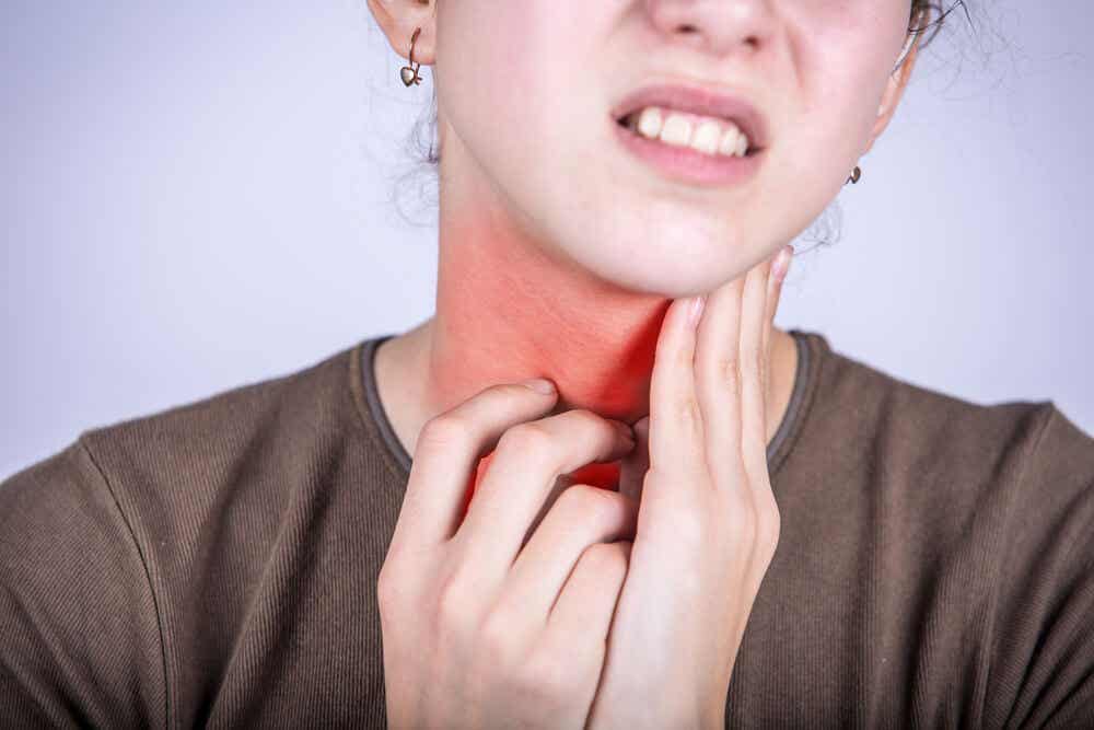 Mujer con la garganta inflamada. Uno de los síntomas de la faringitis.