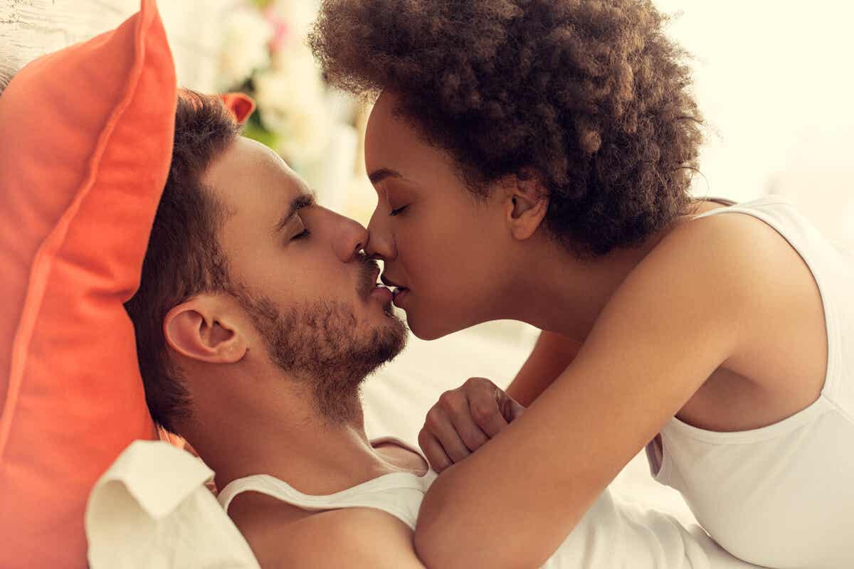 Couple s'embrassant au lit.
