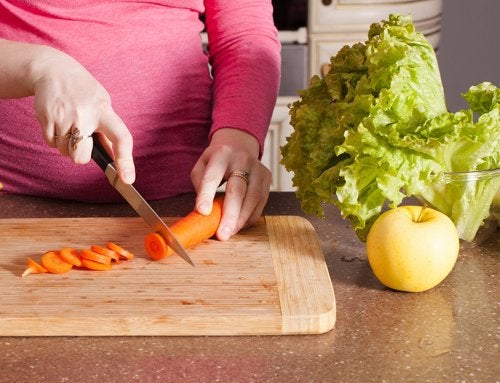 Chica embarazada picando zanahoria