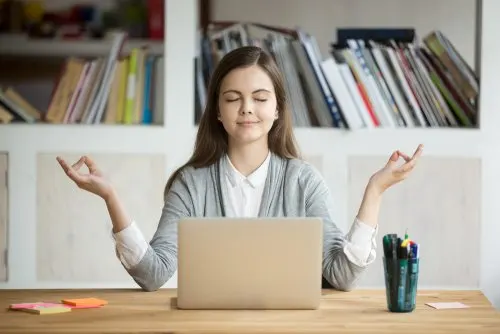 Mujer meditando delante de un ordenador