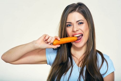 Chica comiendo una zanahoria como símbolo de los beneficios de la zanahoria para la piel