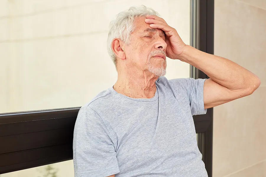 Hombre mayor con dolor de cabeza y mareo.