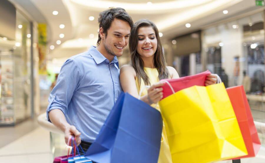 Pareja de compras adquiriendo necesidades innecesarias.