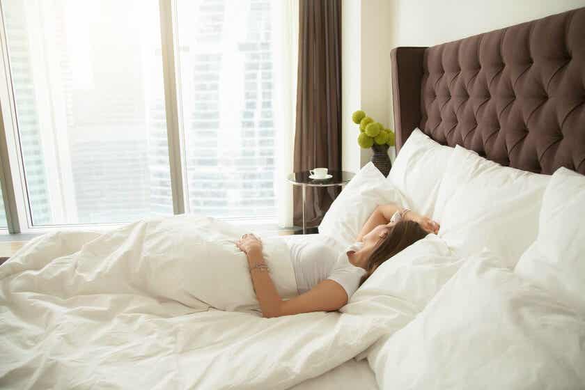 Mujer durmiendo boca arriba en un colchón duro