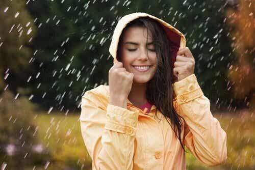 mujer bajo la lluvia feliz por prevenir la ansiedad 