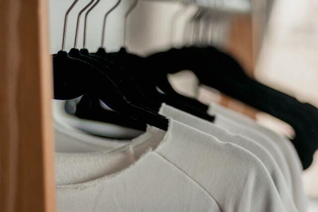 Ropa blanca en perchas.