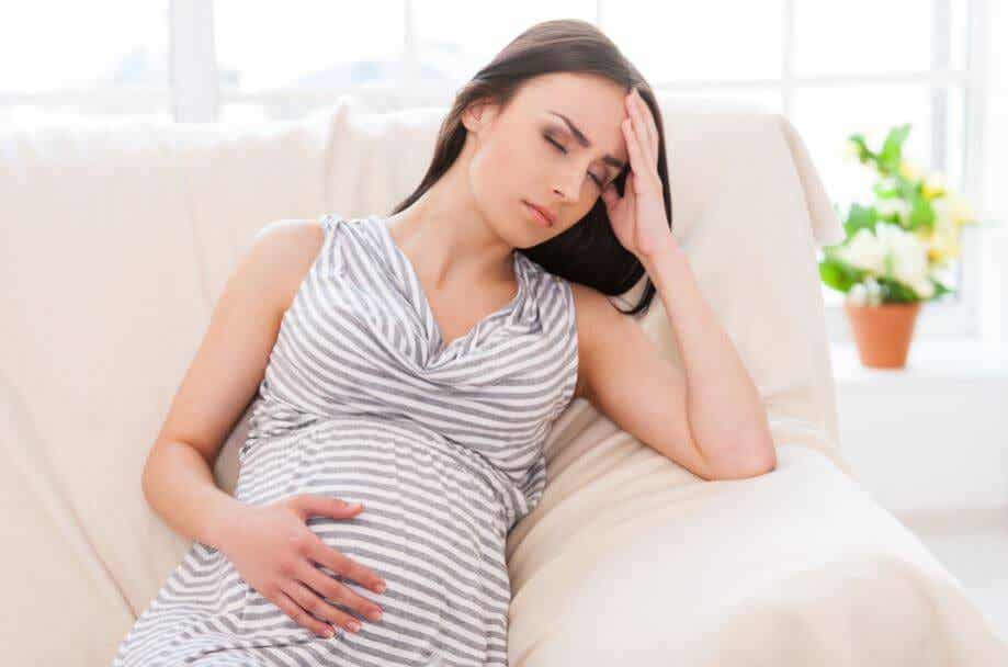 Mujer embaraza en el sofá.