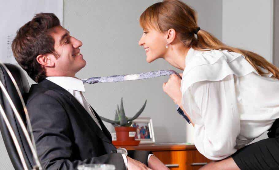 Mujer acercando a un hombre hacia ella tirándole de la corbata