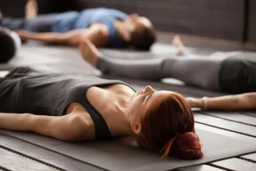 Personas en una de las posturas básicas de yoga