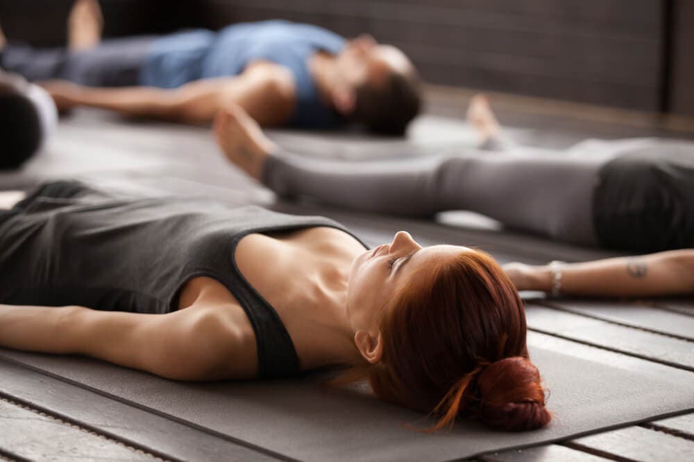 Personas en una de las posturas básicas de yoga
