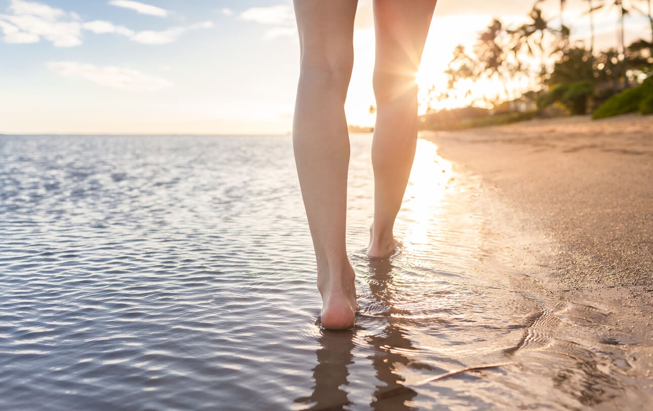 Caminar descalzo por la playa para el dolor de pies