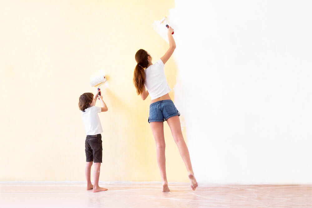 Zwiebeln im Haushalt - Frau mit Kind beim Streichen einer Wand