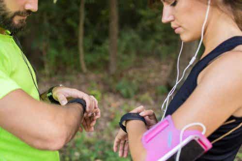 Entrenador con una chica mirando sus relojes: diferencias entre coach y psicólogo deportivo