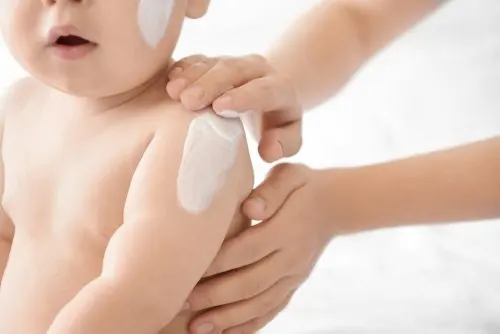 Bebé con crema en el cuerpo