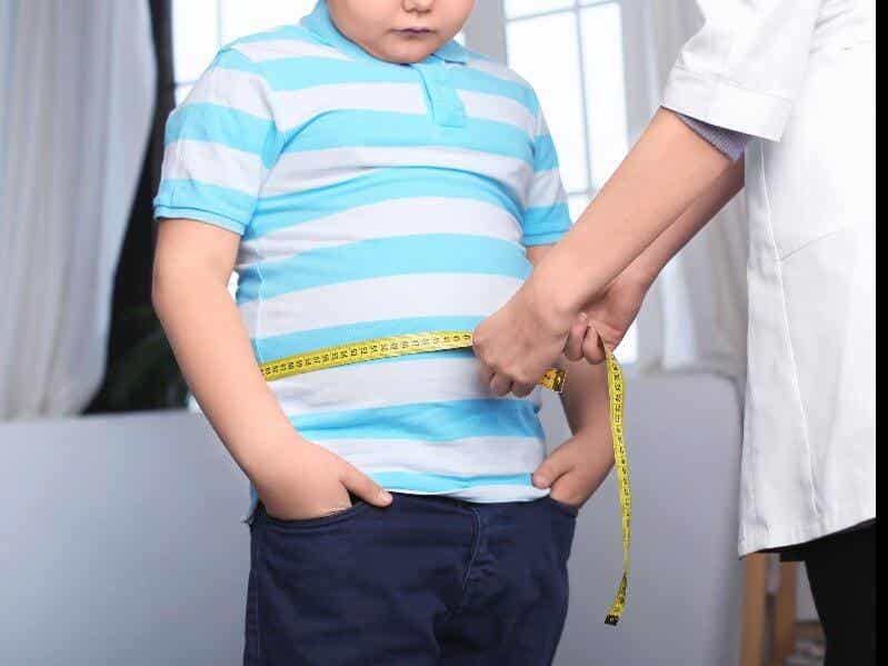 Fettleibigkeit beeinflusst die Gesundheit - Ärztin misst Bauchumfang eines Jungen