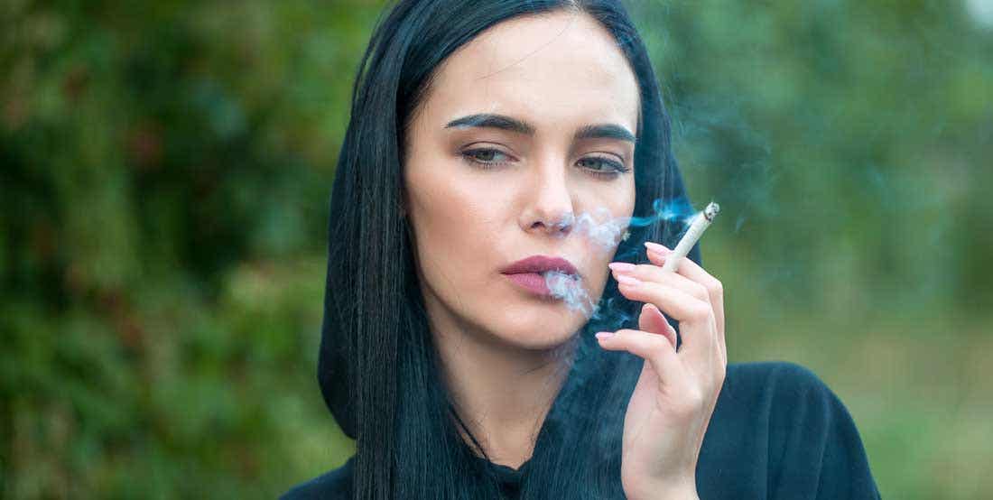 Mujer fumando un cigarro.