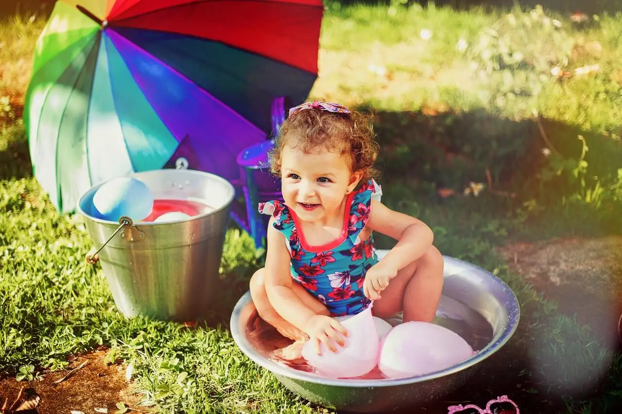 Niña jugando con globos de agua