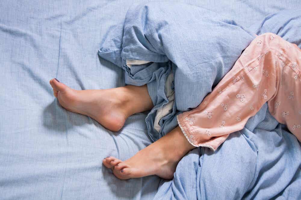 Mujer con problemas de sueño por padecer piernas inquietas.