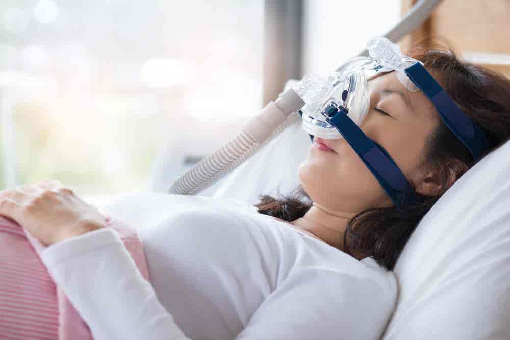 Mujer dormida con mascarilla de apnea para controlar los ronquidos