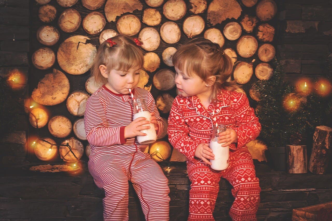 Dos niñas en pijama bebiendo leche durante una de las actividades para hacer en casa.