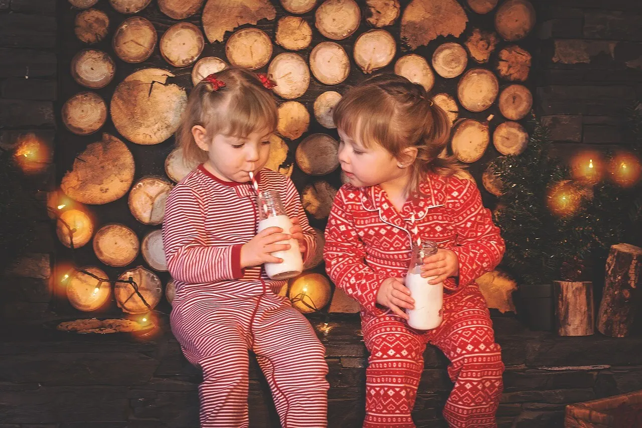 Dos niñas en pijama bebiendo leche durante una de las actividades para hacer en casa.