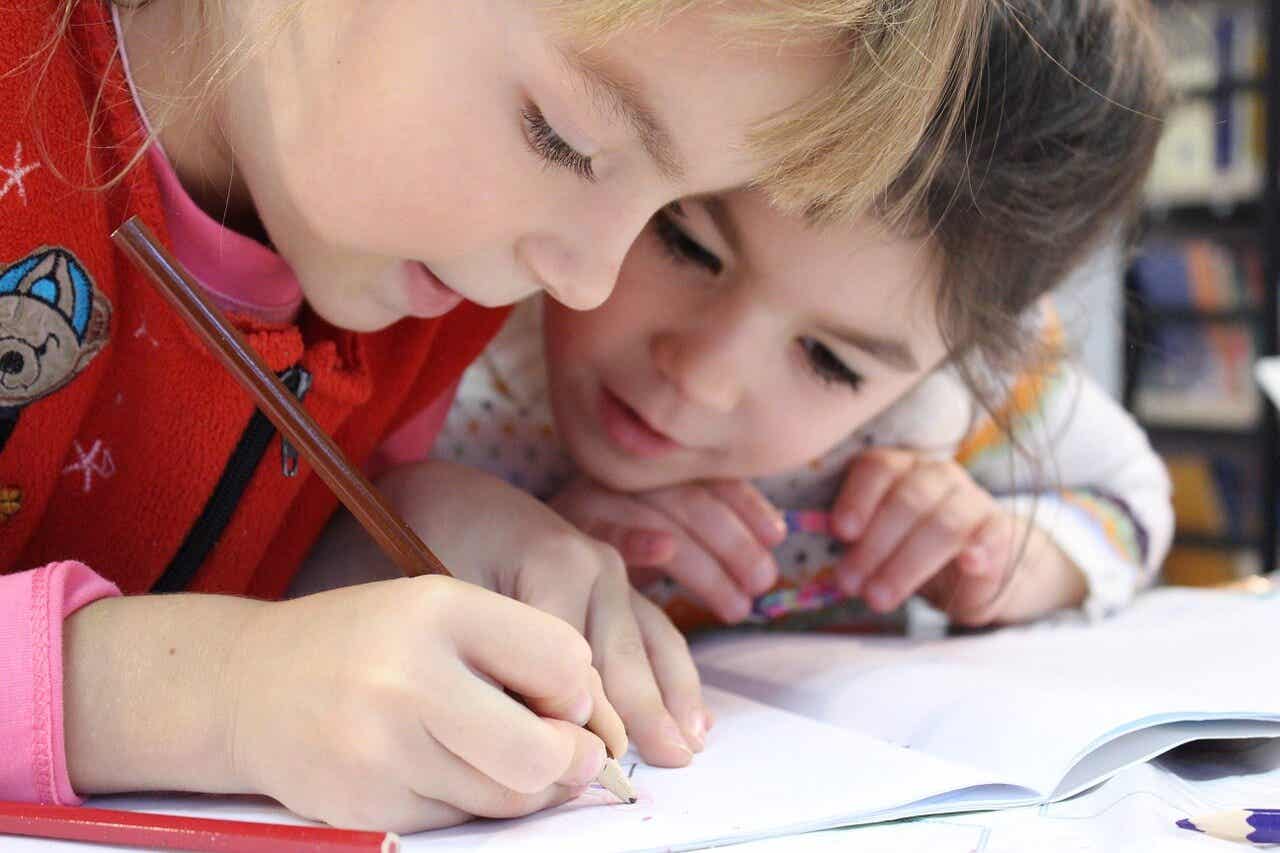 Niños dibujando con un lápiz-
