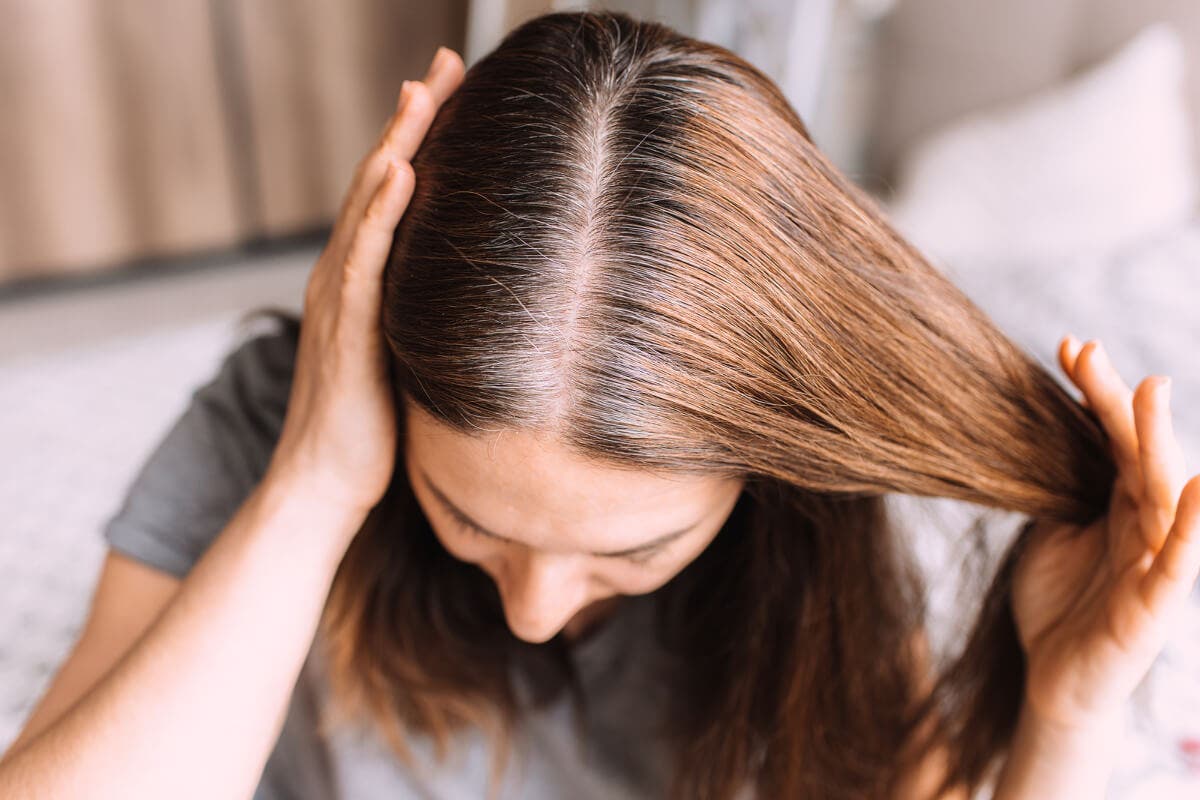 Mujer revisa sus canas.