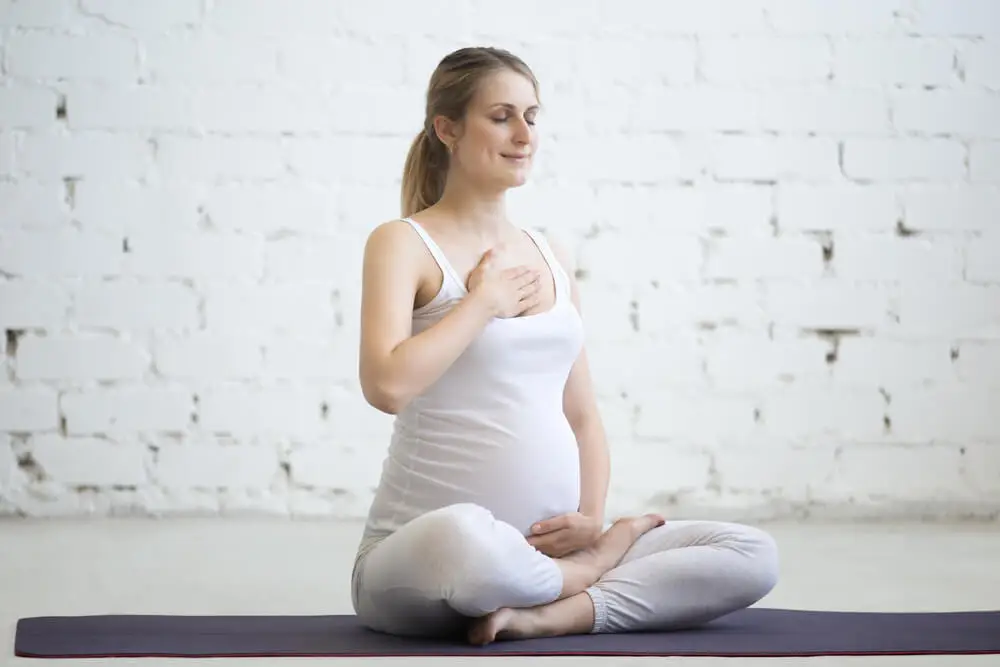 Mujer embarazada haciendo yoga.