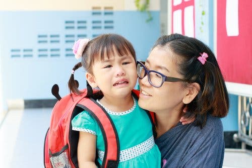 Madre acompañando a su hija a la escuela.