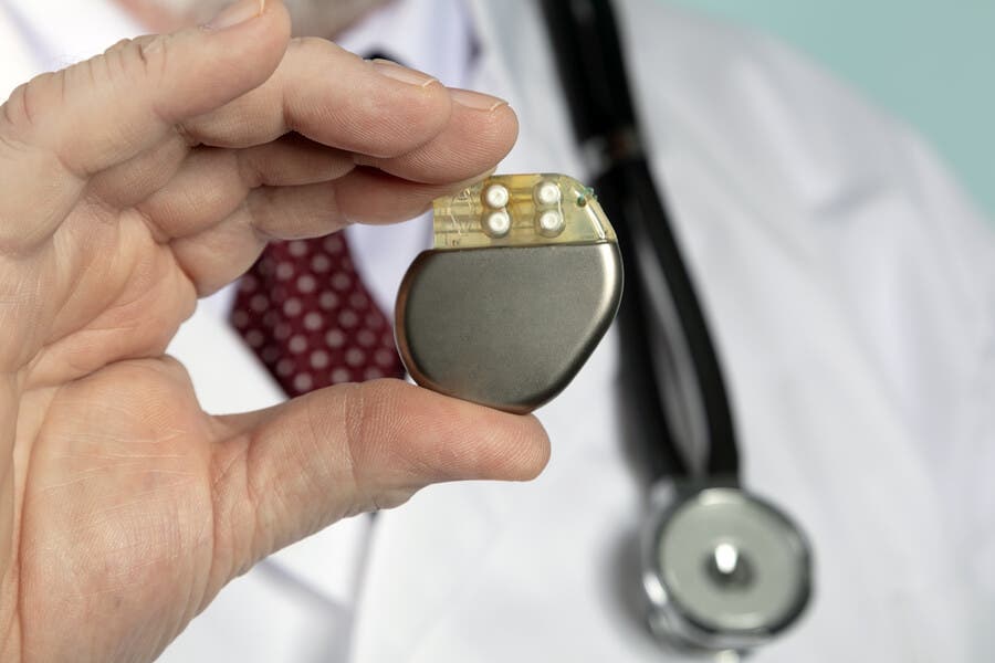 Docteur tenant un stimulateur cardiaque.