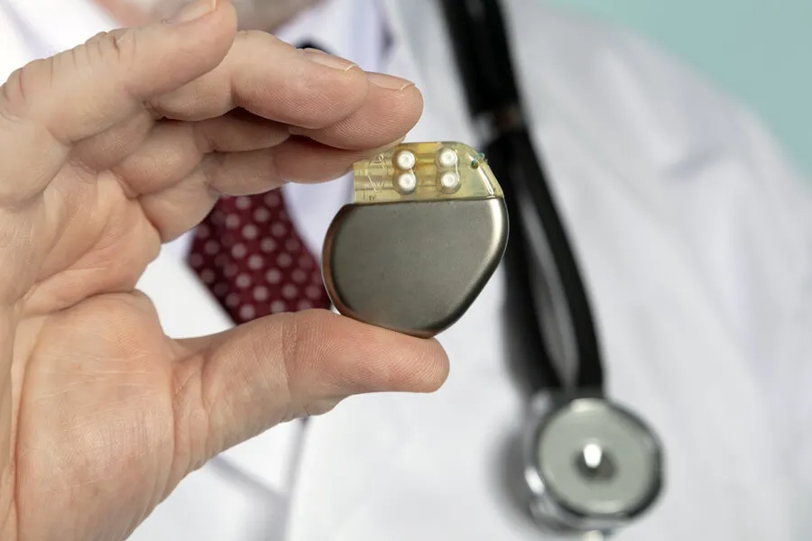 Médico sosteniendo marcapasos cardíaco.