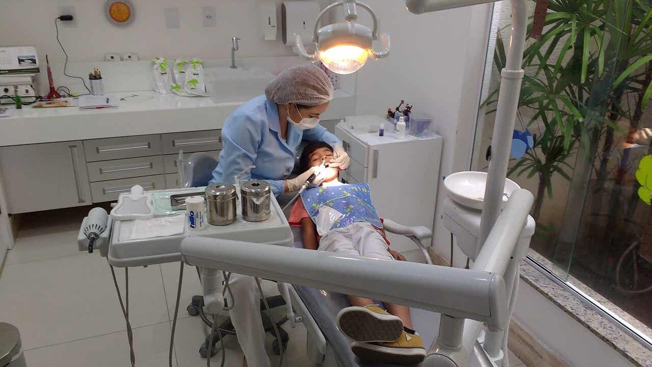 Dentista con un niño en la camilla.