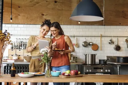 Personas cocinando en actitud risueña: decoración de cocinas rústicas