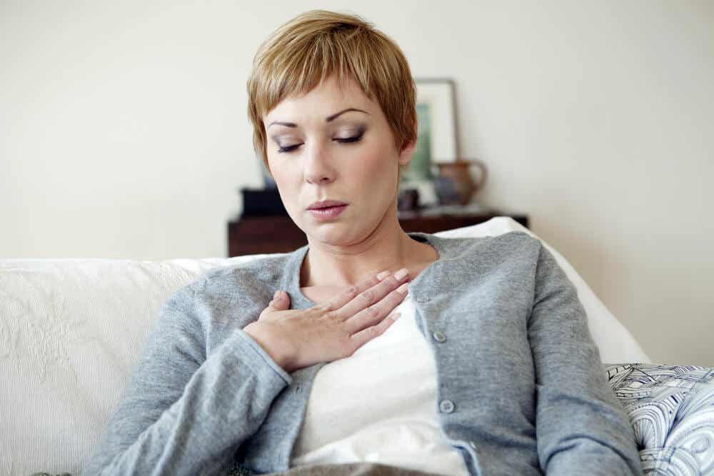 Mujer sufriendo un ataque de calor por estar en la edad de la menopausia