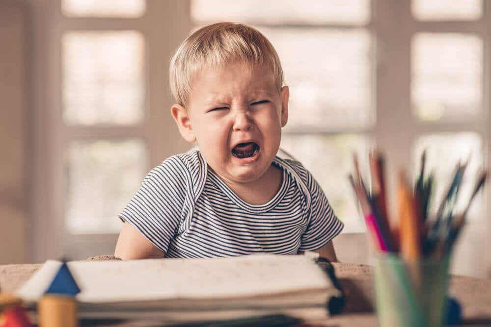 Niño llorando porque sufre estrés infantil.
